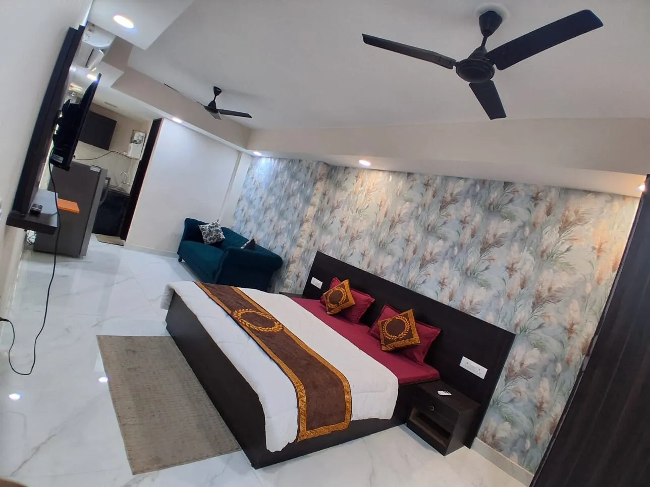 Spacious, fully furnished premium PG room at Gurugram Stayz with double bed, sofa and designer feature wall